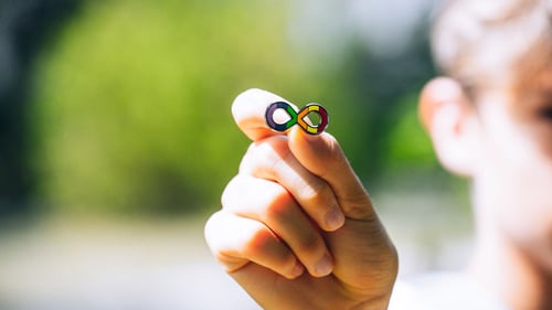 A boy holding an autism affinity badge